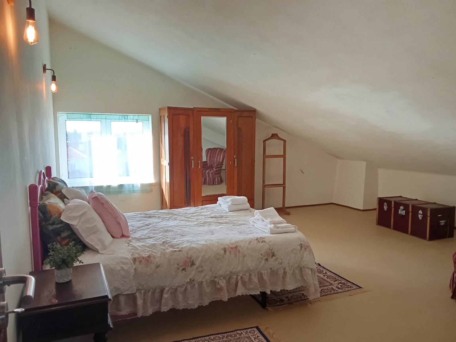 Quarto de casal com guarda fatos cl�ssico, cabide de p�, ba� e janela - perspectiva vista da porta