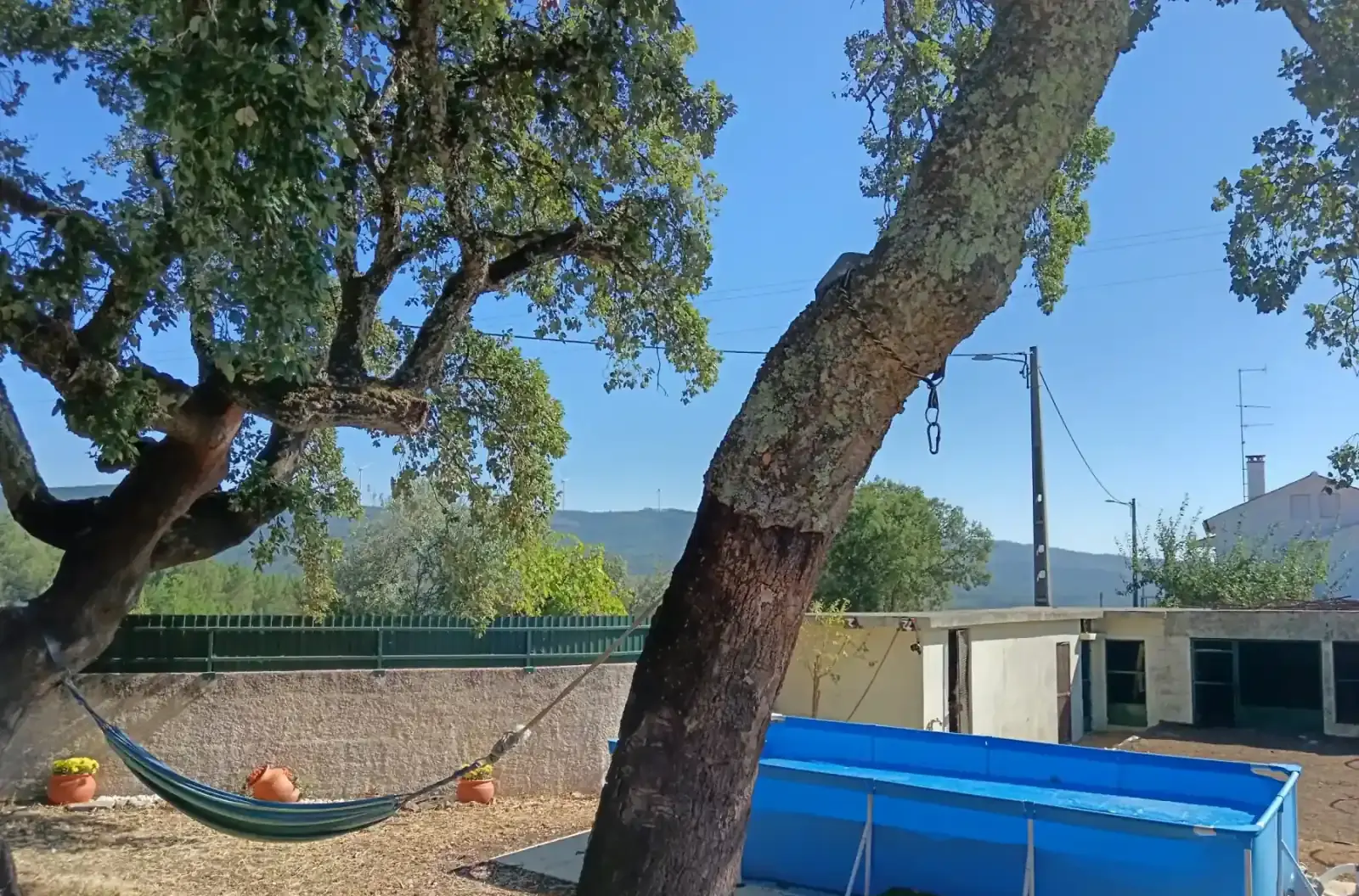 Pátio privativo com rede de descanso e piscina à sombra de sobreiros, em Proença-a-Nova